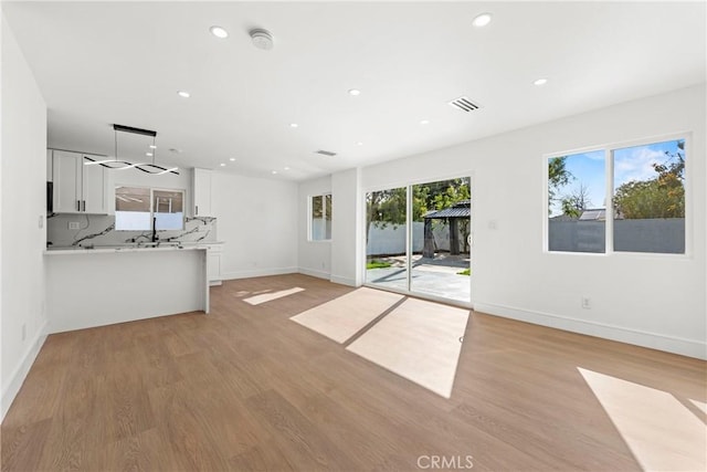 unfurnished living room with baseboards, recessed lighting, visible vents, and light wood-style floors