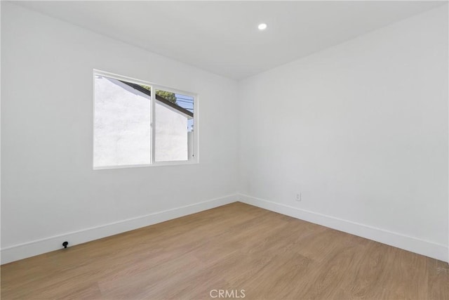 spare room featuring baseboards, light wood-style flooring, and recessed lighting