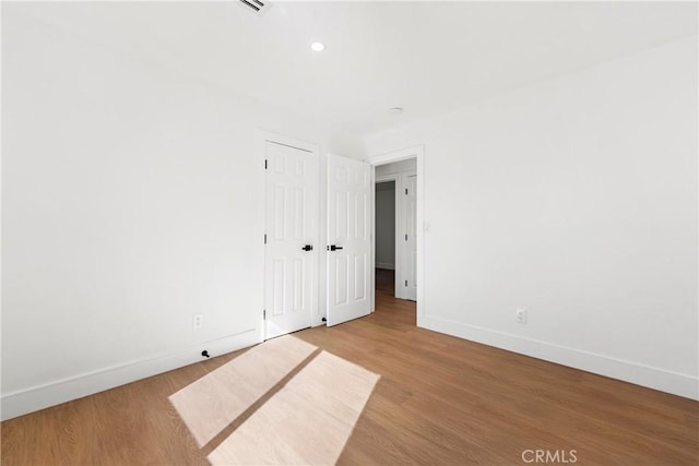 empty room with recessed lighting, baseboards, and light wood-type flooring