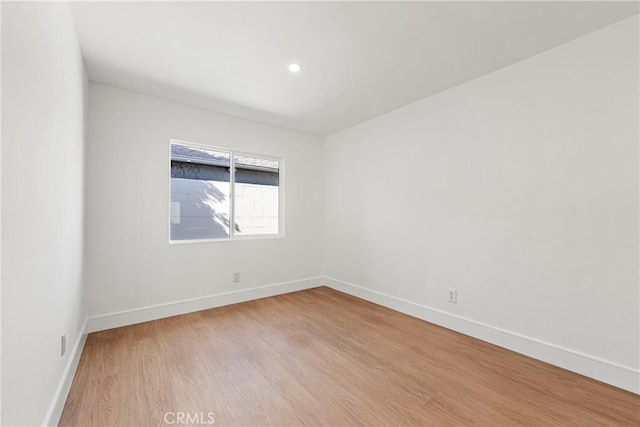 spare room with recessed lighting, baseboards, and wood finished floors