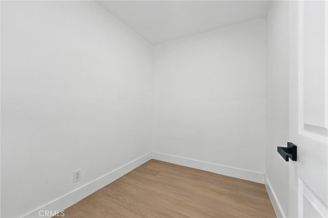 empty room with baseboards and light wood-style floors