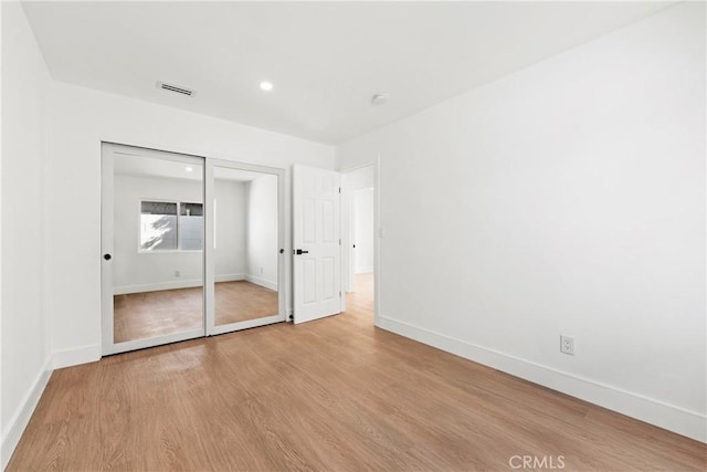 unfurnished bedroom featuring a closet, visible vents, light wood finished floors, baseboards, and recessed lighting