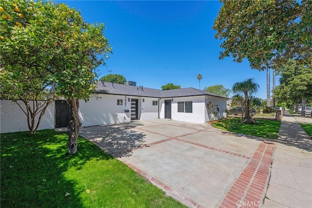 single story home featuring a front yard, stucco siding, fence, and a patio
