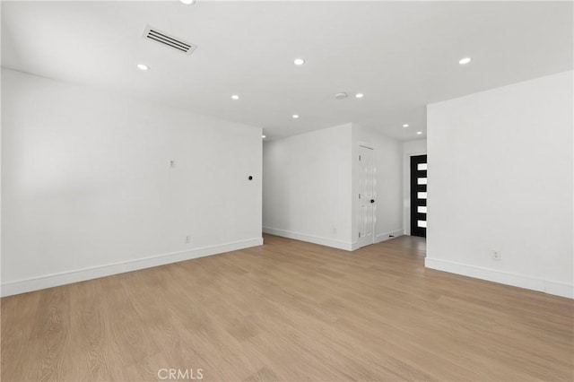 empty room featuring visible vents, baseboards, light wood-style floors, and recessed lighting
