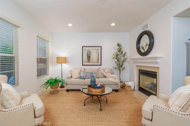 living room featuring recessed lighting, baseboards, visible vents, and a fireplace