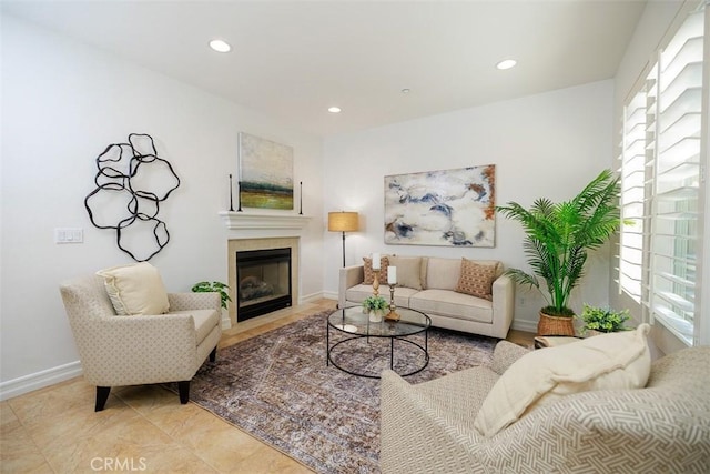 living area with baseboards, a fireplace with flush hearth, and recessed lighting