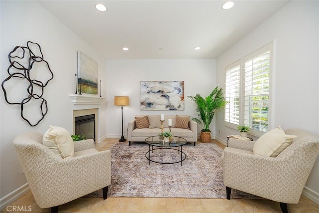 living area featuring baseboards, a fireplace, and recessed lighting