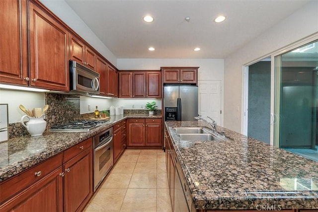 kitchen featuring recessed lighting, a sink, appliances with stainless steel finishes, and a kitchen island with sink