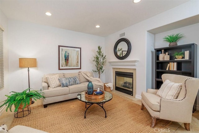 living room with recessed lighting, visible vents, and a tiled fireplace