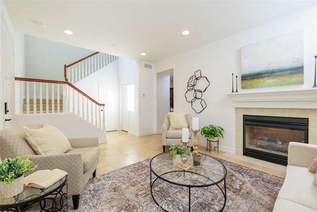 living room featuring visible vents, tile patterned flooring, stairs, a tile fireplace, and recessed lighting
