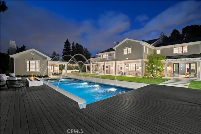 outdoor pool featuring a patio, an outdoor fire pit, and a deck