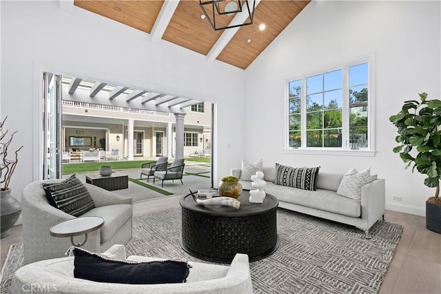 living area featuring wooden ceiling, high vaulted ceiling, a healthy amount of sunlight, and ornate columns