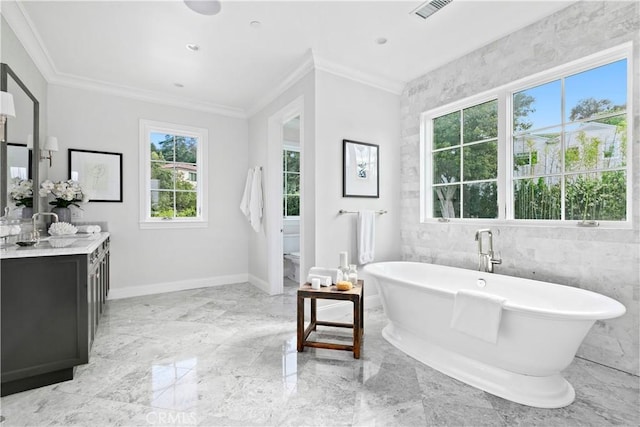 full bath featuring marble finish floor, visible vents, a freestanding tub, and ornamental molding