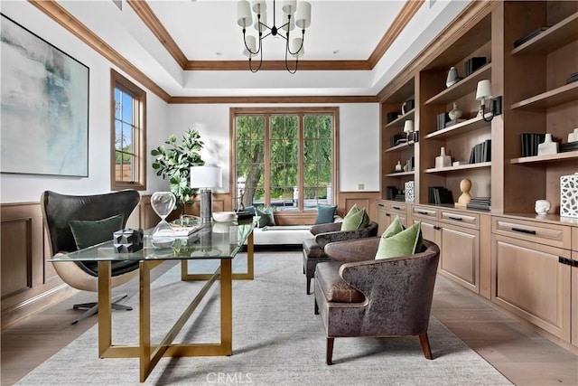 office space featuring a wainscoted wall, crown molding, built in shelves, wood finished floors, and a notable chandelier