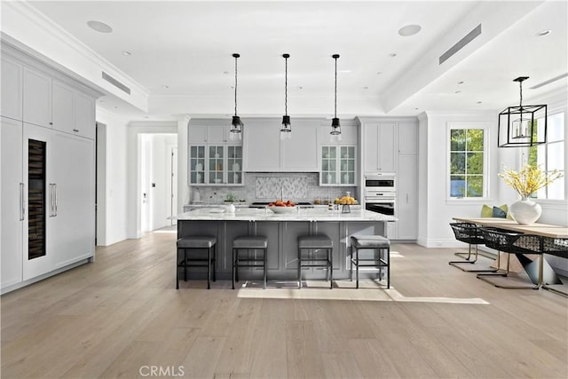 kitchen with a tray ceiling, backsplash, and ornamental molding