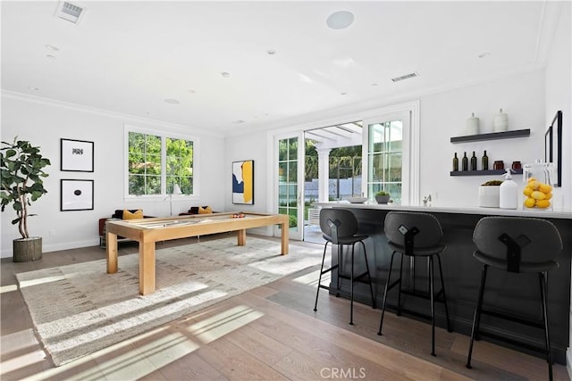 dining room featuring visible vents, crown molding, and wood finished floors