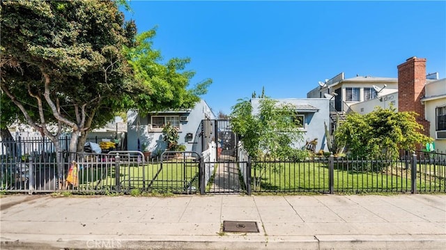 1361 W Vernon Ave, Los Angeles, CA 90037 - view of front of house featuring stucco siding, a fenced front yard, and a front lawn