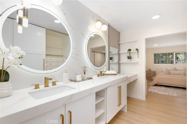 2405 Via Mariposa W Unit 1B, Laguna Woods, CA 92637 - ensuite bathroom with double vanity, wood finished floors, and recessed lighting