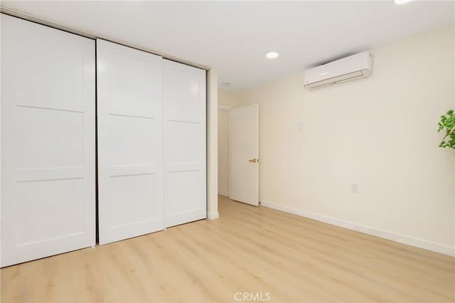 2405 Via Mariposa W Unit 1B, Laguna Woods, CA 92637 - unfurnished bedroom featuring a wall mounted AC, light wood-style flooring, baseboards, a closet, and recessed lighting
