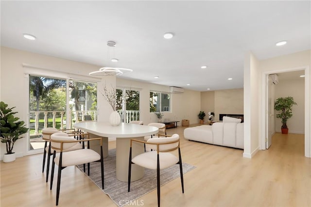 2405 Via Mariposa W Unit 1B, Laguna Woods, CA 92637 - dining space featuring an AC wall unit, healthy amount of natural light, light wood-style flooring, recessed lighting, and baseboards