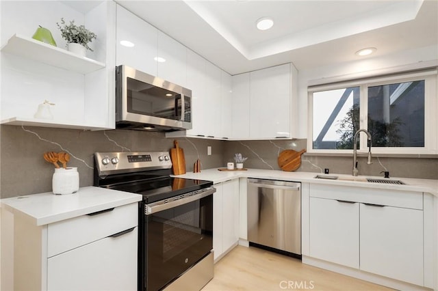 2405 Via Mariposa W Unit 1B, Laguna Woods, CA 92637 - kitchen with stainless steel appliances, a sink, white cabinetry, open shelves, and light countertops