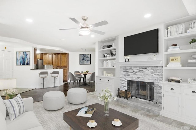 11365 Affinity Ct Unit 192, San Diego, CA 92131 - living room with built in shelves, ceiling fan, a fireplace, and recessed lighting