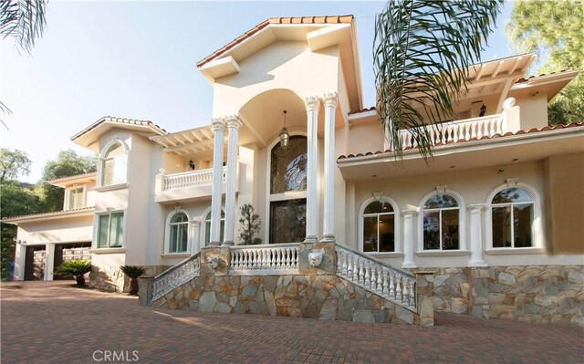 22751 Plummer St, Chatsworth, CA 91311 - exterior space featuring stone siding, stucco siding, a balcony, a tiled roof, and decorative driveway
