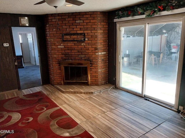 1420 S Butler Ave, Compton, CA 90221 - unfurnished living room with a ceiling fan, a textured ceiling, and a fireplace