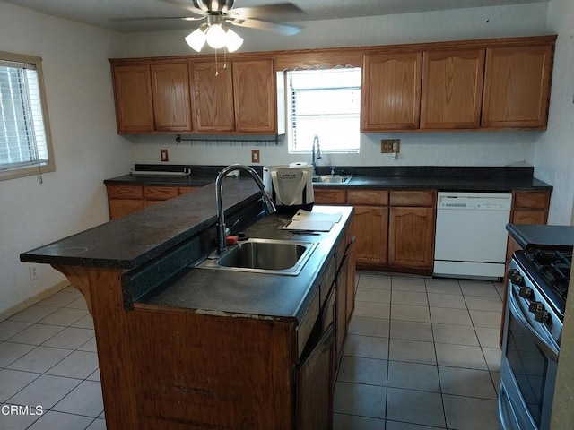 1420 S Butler Ave, Compton, CA 90221 - kitchen featuring white dishwasher, stainless steel gas range oven, a kitchen island with sink, and dark countertops