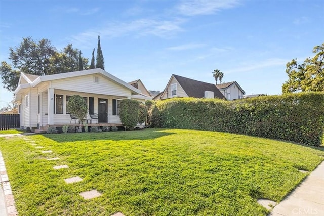 view of front of house with covered porch and a front lawn