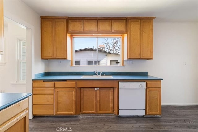 kitchen featuring a sink, dishwasher, brown cabinetry, baseboards, and dark wood-style flooring