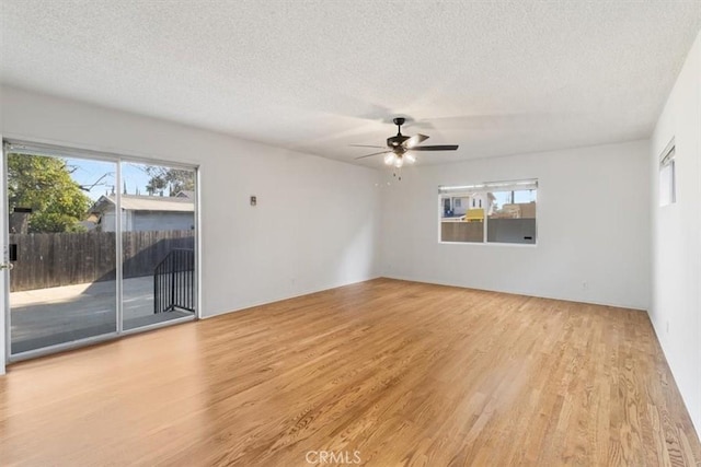 empty room with wood finished floors, a textured ceiling, and ceiling fan