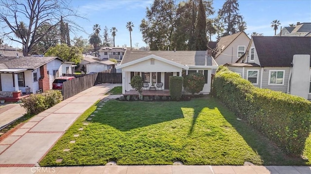 bungalow-style house with a residential view, driveway, a front yard, and fence