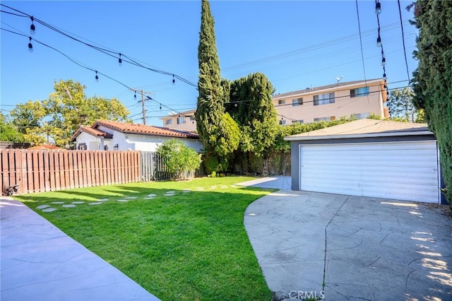 view of yard featuring an outbuilding, fence, and a garage