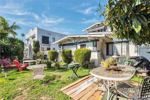 rear view of property with stucco siding and outdoor dining area