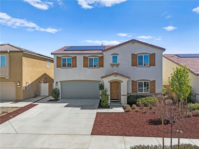 1772 Old Wagon Dr, Hemet, CA 92545 - mediterranean / spanish house featuring driveway, stucco siding, a garage, and solar panels
