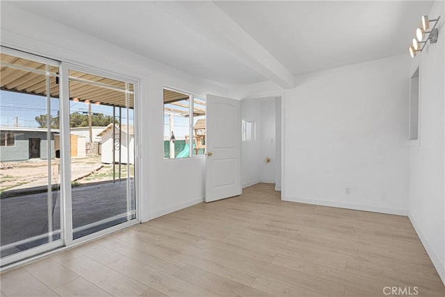 spare room with baseboards and light wood-style flooring