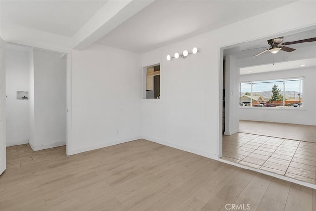 unfurnished room with baseboards, a ceiling fan, and wood finished floors