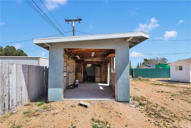 view of outdoor structure with fence and an outbuilding