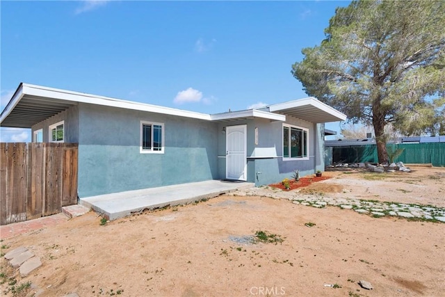 view of front of house featuring fence and stucco siding