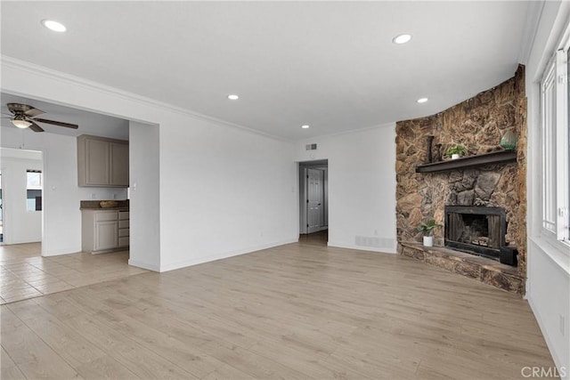 unfurnished living room featuring recessed lighting, ceiling fan, light wood-type flooring, and a stone fireplace