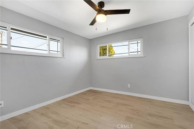 unfurnished room featuring a ceiling fan, baseboards, and light wood finished floors