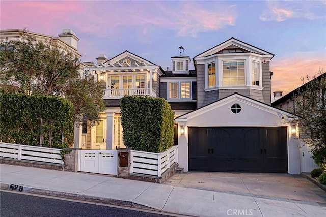 528 15th St, Manhattan Beach, CA 90266 - view of front facade with a balcony, concrete driveway, a fenced front yard, and an attached garage