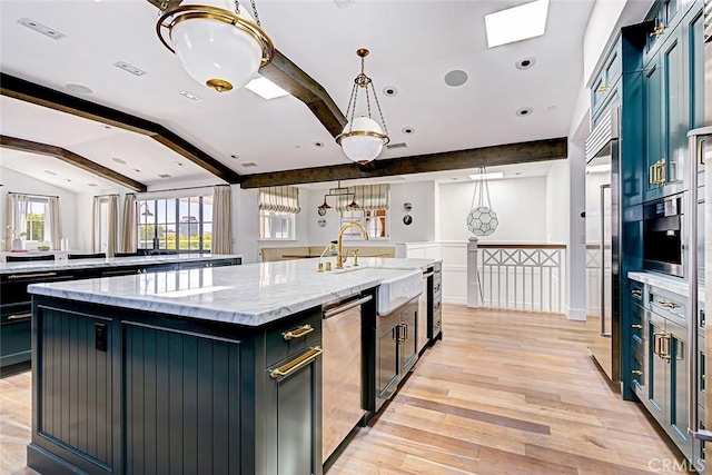528 15th St, Manhattan Beach, CA 90266 - kitchen featuring light wood-style flooring, light stone countertops, stainless steel appliances, a spacious island, and lofted ceiling with skylight