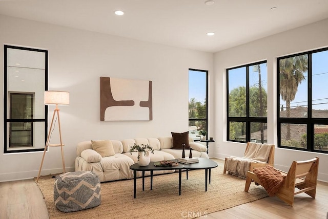 living area with light wood-style flooring, recessed lighting, and baseboards