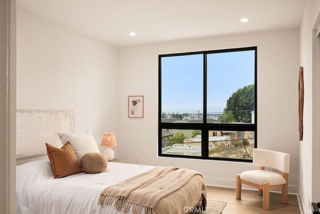 bedroom with recessed lighting, multiple windows, and wood finished floors