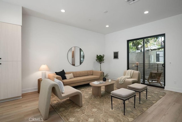 living room featuring light wood-type flooring, baseboards, visible vents, and recessed lighting