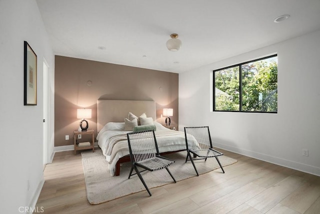 bedroom featuring light wood-style floors and baseboards