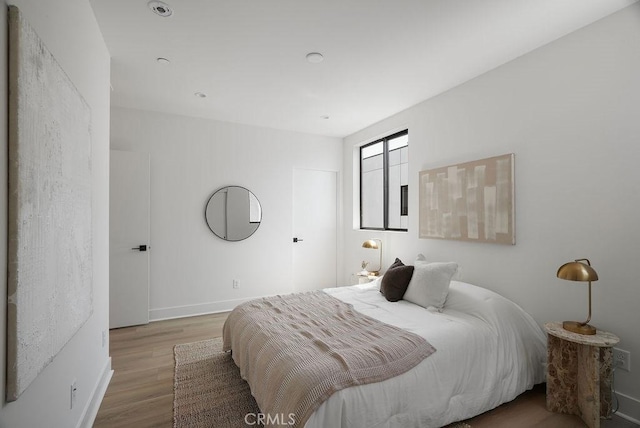bedroom with baseboards and wood finished floors
