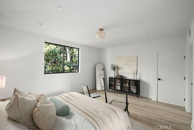 bedroom featuring light wood-style flooring and baseboards
